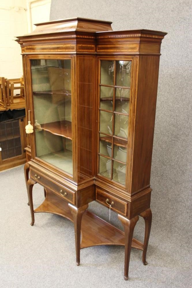 AN EDWARDIAN MAHOGANY DISPLAY CABINET of breakfront form crossbanded with stringing Image