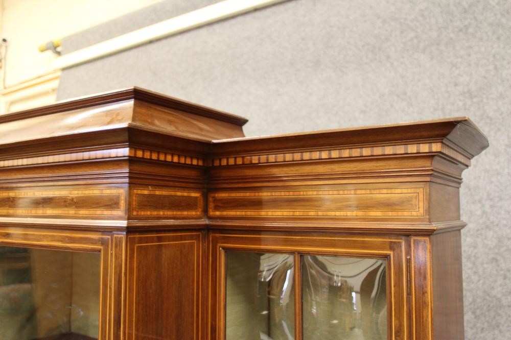 AN EDWARDIAN MAHOGANY DISPLAY CABINET of breakfront form crossbanded with stringing Image