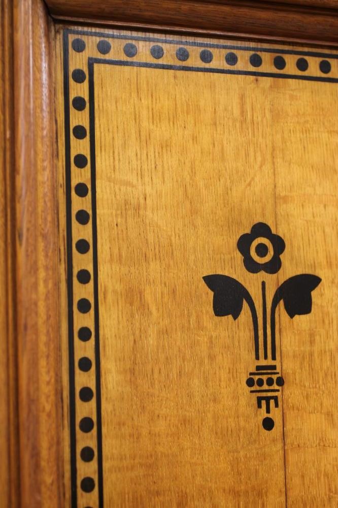 A GOTHIC REVIVAL LIGHT OAK AND BLACK STENCILLED WARDROBE Image