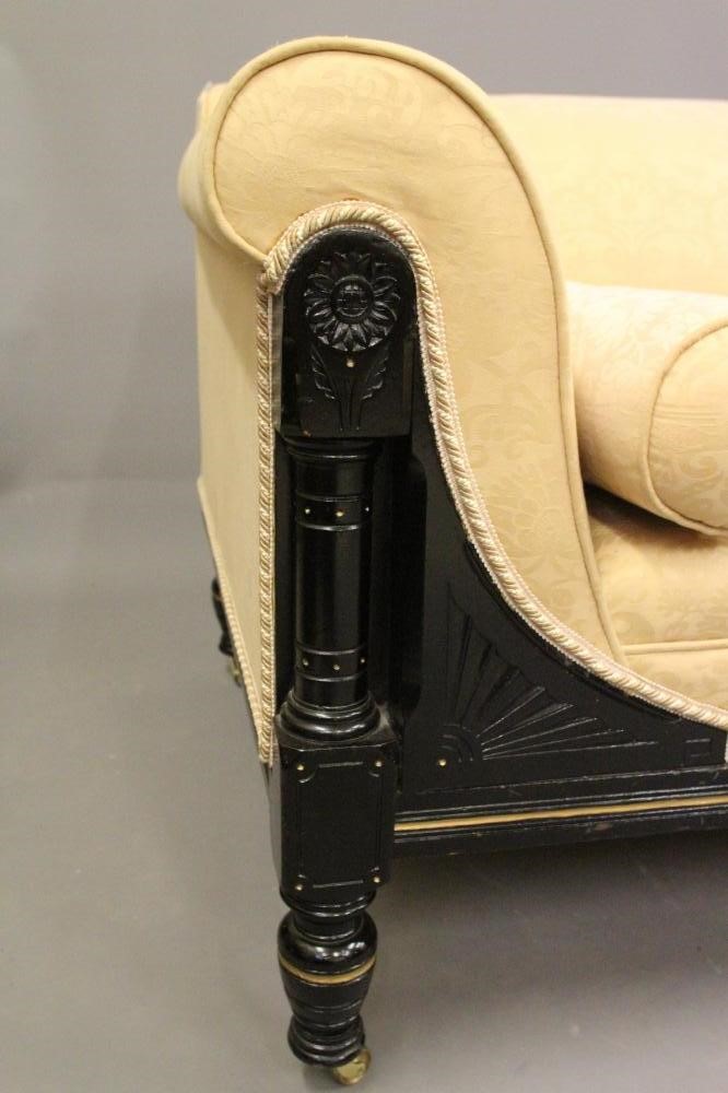 A VICTORIAN EBONISED AND PARCEL GILT CLUB SETTEE in the Aesthetic taste Image