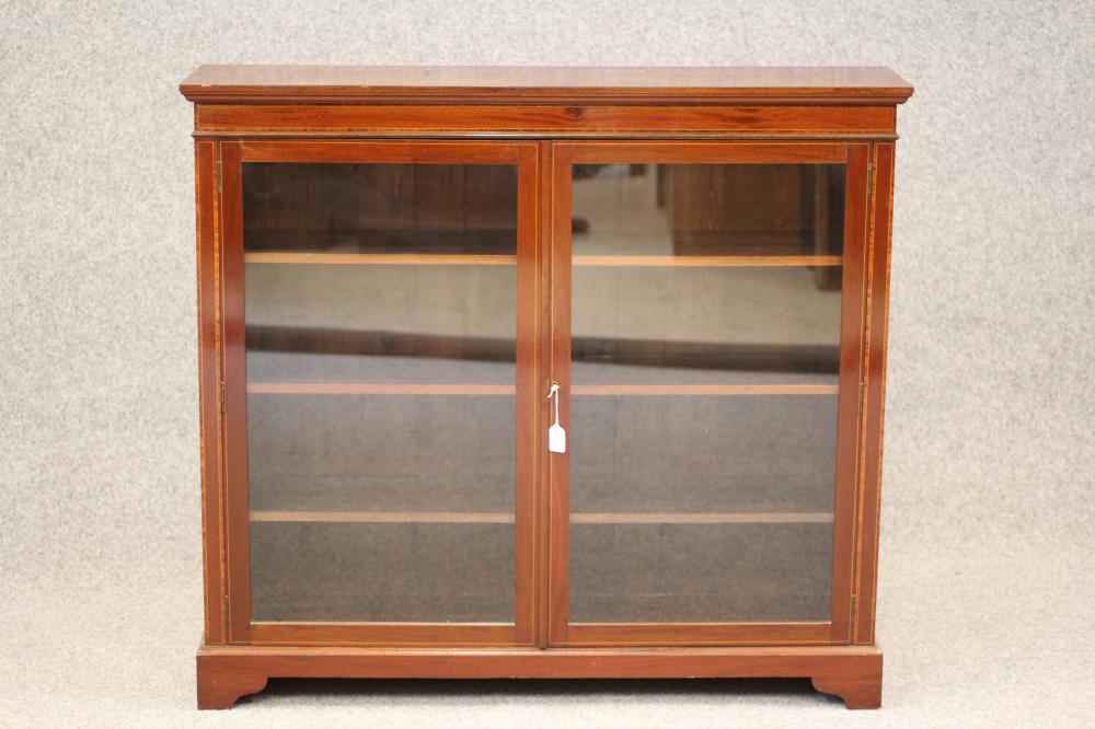 AN EDWARDIAN MAHOGANY BOOKCASE of shallow oblong form Image