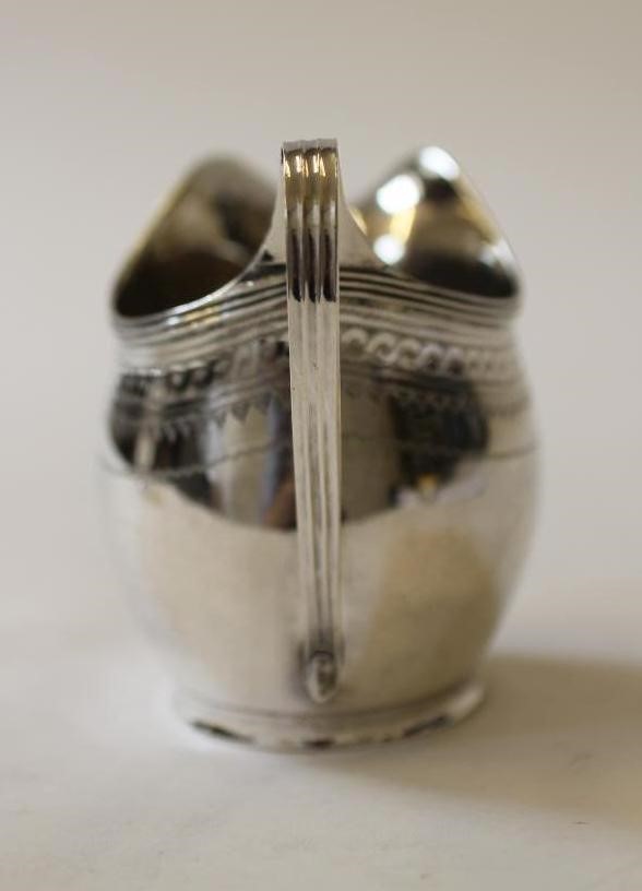 A GEORGE III SILVER HELMET MILK JUG Image