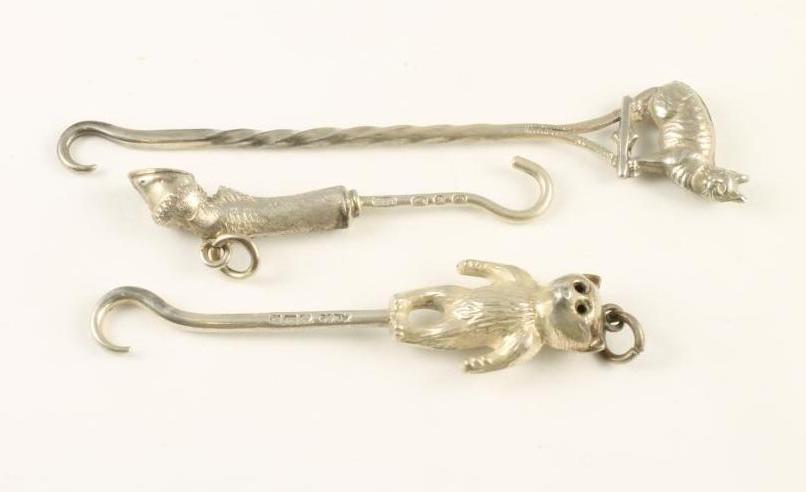 A COLLECTION OF THREE NOVELTY SILVER MINIATURE BUTTON HOOKS Image