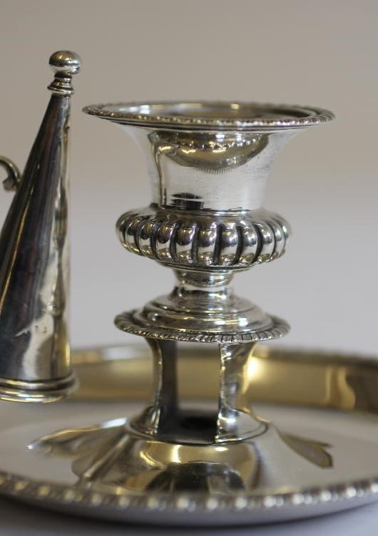 A LATE GEORGE III SILVER CHAMBERSTICK AND EXTINGUISHER Image