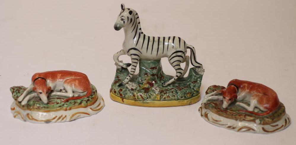 TWO LATE VICTORIAN STAFFORDSHIRE POTTERY MODELS OF RECUMBENT GREYHOUNDS Image