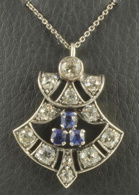 AN ART DECO DIAMOND AND SAPPHIRE PENDANT of stylised open anthemion form centred by three facet cut Image