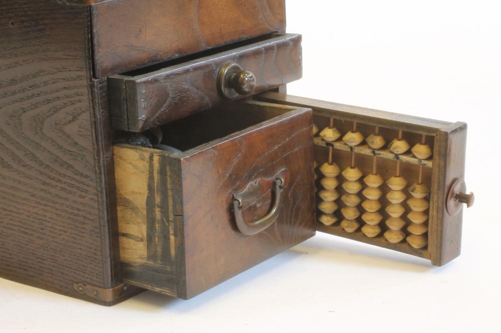 A CHINESE STAINED WOOD WRITING BOX of oblong form with copper mounts and loop handles Image