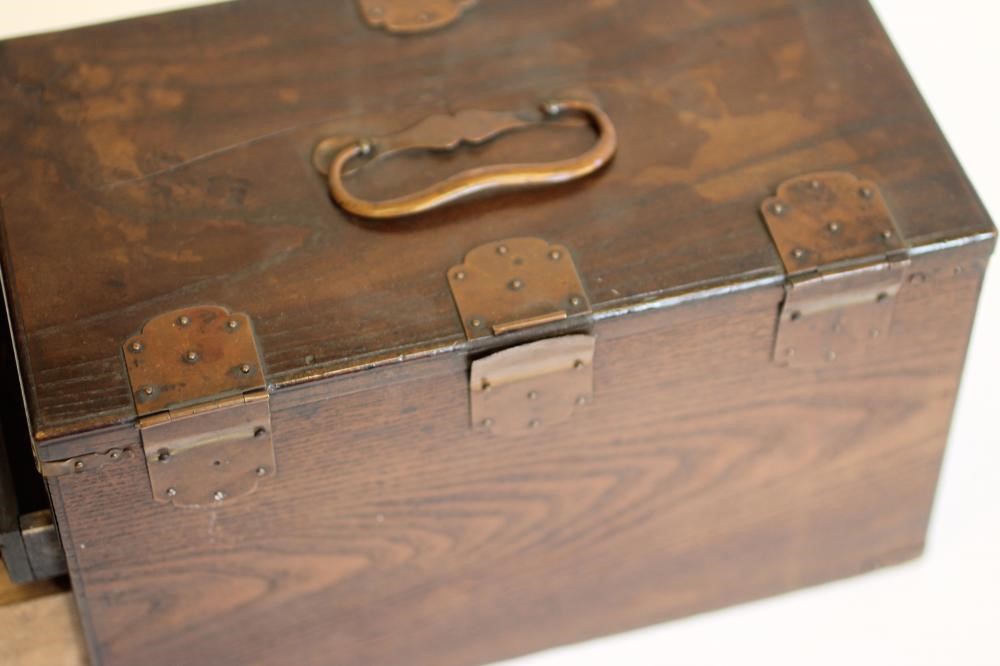 A CHINESE STAINED WOOD WRITING BOX of oblong form with copper mounts and loop handles Image
