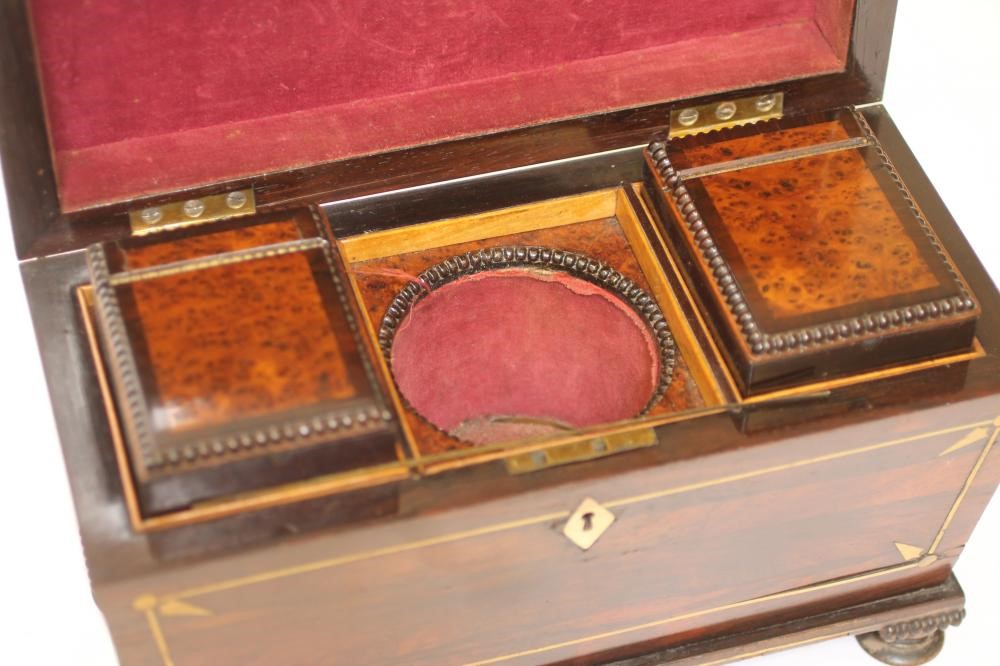 A REGENCY ROSEWOOD TEA CHEST of sarcophagus form with brass stringing and reel edging Image