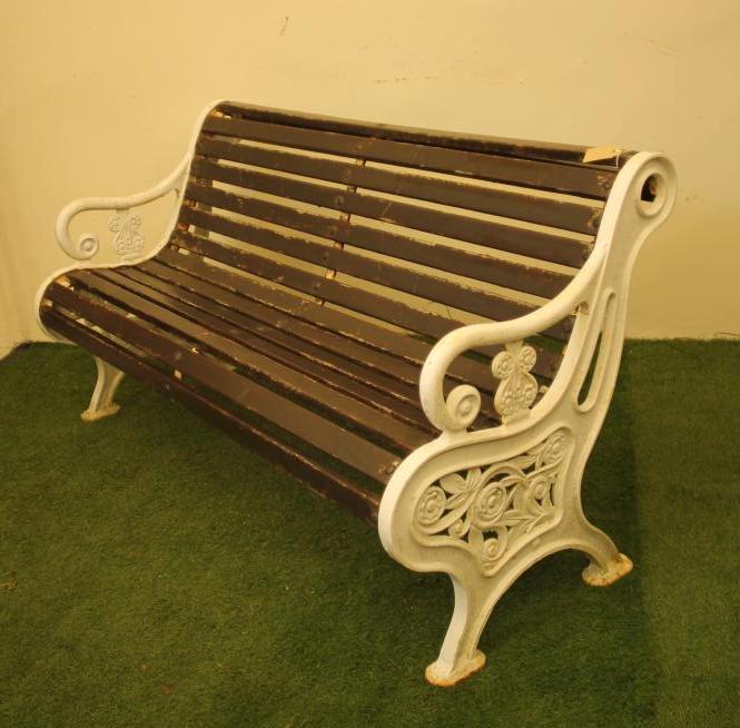 A CAST IRON PARK BENCH of scroll back form with slatted wood seat and back Image