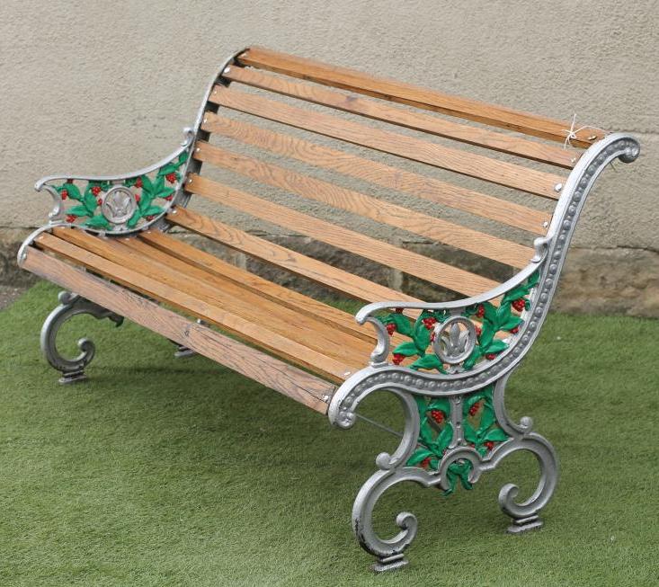 A VICTORIAN CAST IRON GARDEN BENCH of scroll back form with slatted hardwood seat and back Image