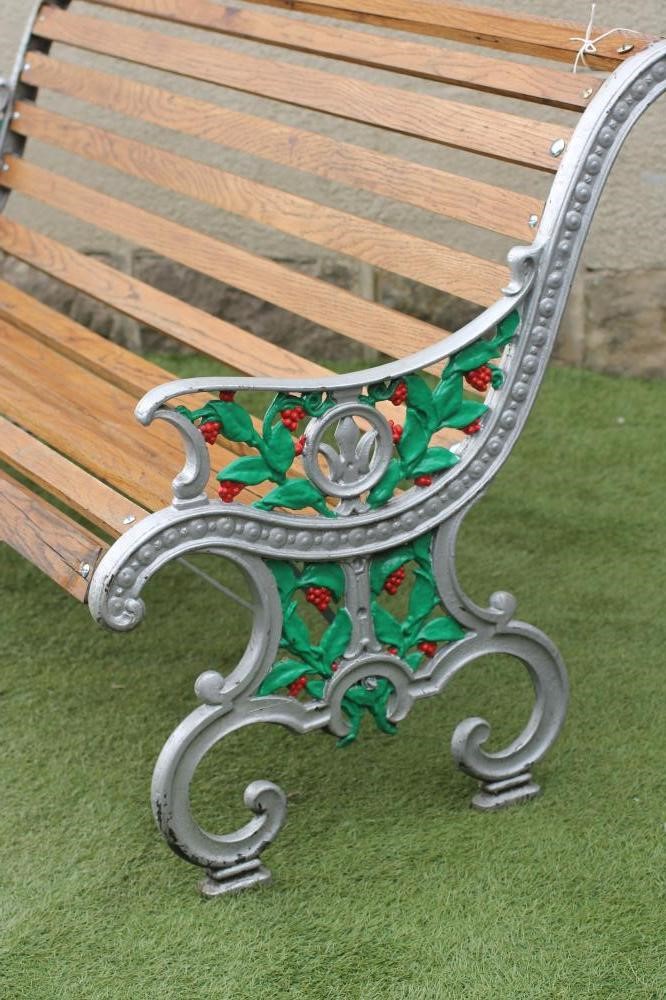 A VICTORIAN CAST IRON GARDEN BENCH of scroll back form with slatted hardwood seat and back Image