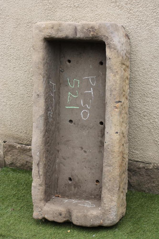 A SANDSTONE TROUGH of rough hewn oblong form sloping forward slightly Image