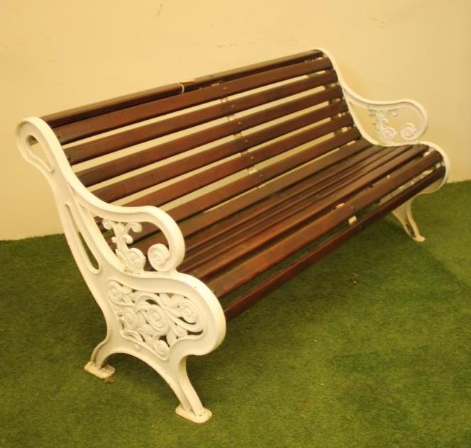 A CAST IRON PARK BENCH of scroll back form with slatted wood seat and back Image