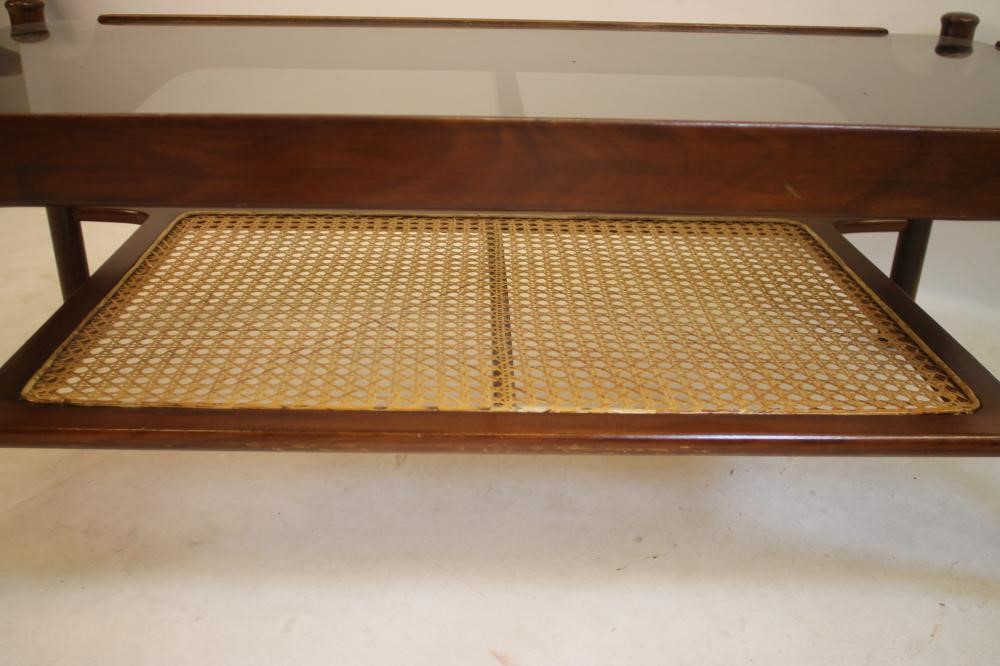 A DANISH HARDWOOD COFFEE TABLE of oblong form with rounded oblong smoke glass top on shaped and Image