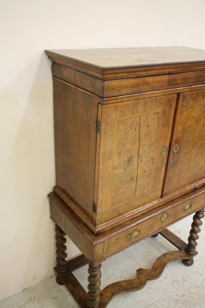 A WILLIAM & MARY WALNUT AND FEATHER BANDED CABINET ON STAND Image