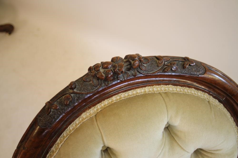 A LADY'S VICTORIAN CARVED WALNUT EASY CHAIR of spoon back form button upholstered in pale green Image