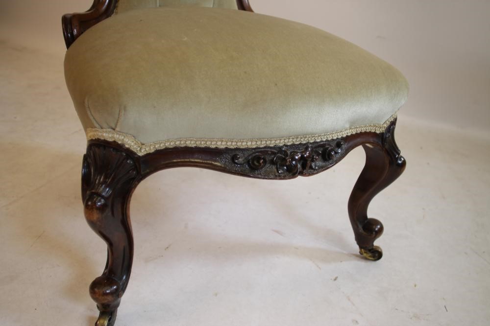 A LADY'S VICTORIAN CARVED WALNUT EASY CHAIR of spoon back form button upholstered in pale green Image