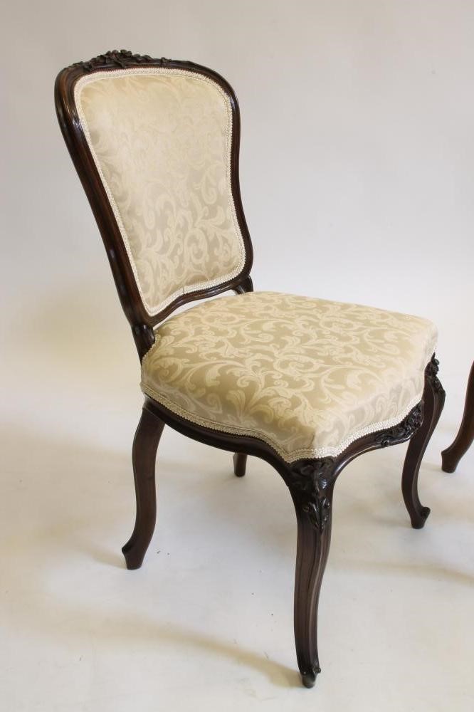 A PAIR OF VICTORIAN CARVED ROSEWOOD SIDE CHAIRS upholstered in champagne damask Image