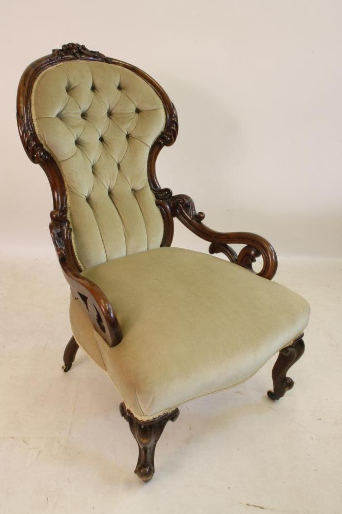 A VICTORIAN CARVED WALNUT FRAMED ARMCHAIR of spoonback form button upholstered in pale green dralon Image