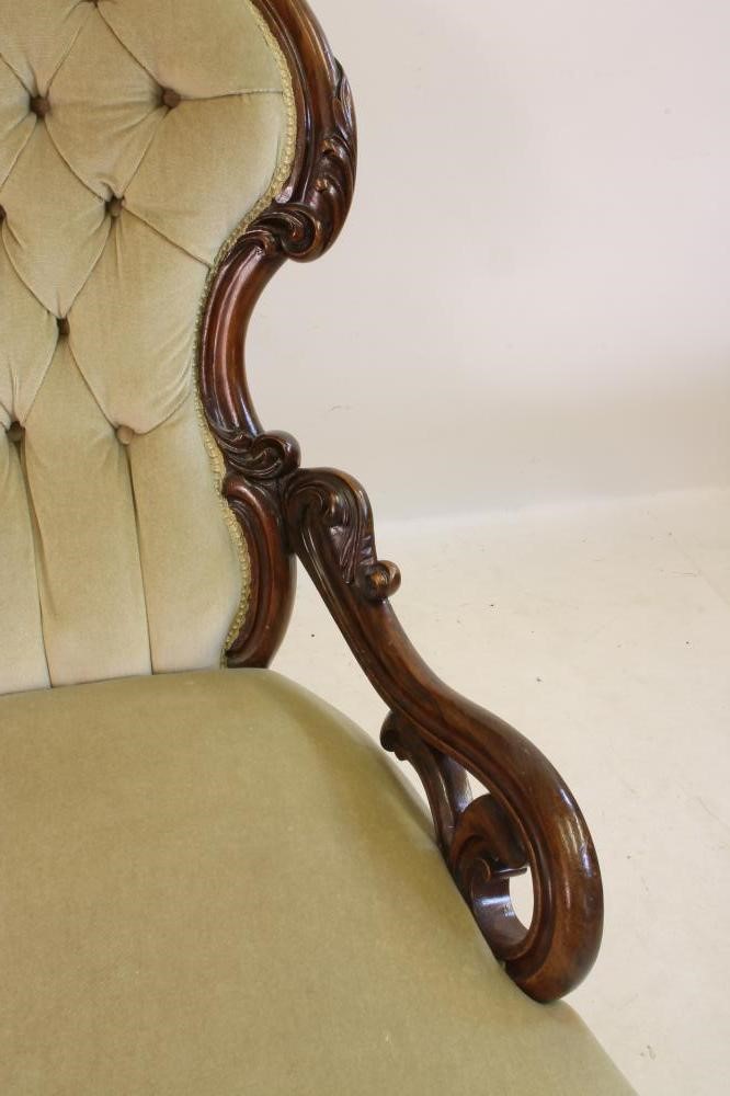 A VICTORIAN CARVED WALNUT FRAMED ARMCHAIR of spoonback form button upholstered in pale green dralon Image