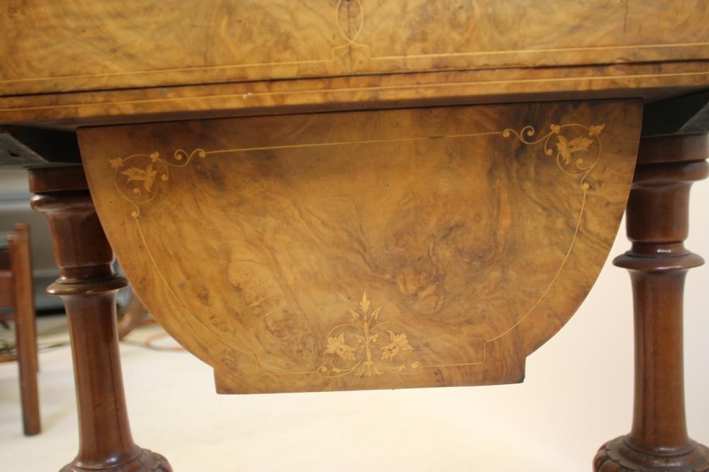 A VICTORIAN BURR WALNUT SEWING/CARD TABLE of rounded oblong form with inlaid floral sprays and Image