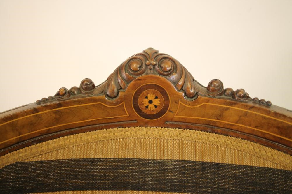 A VICTORIAN WALNUT ARMCHAIR of spoonback form with stringing and marquetry paterae Image