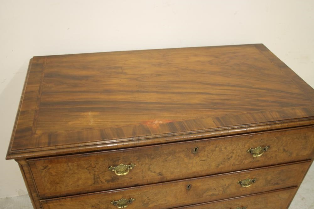 A GEORGIAN WALNUT AND FEATHER BANDED SECRETAIRE CHEST Image