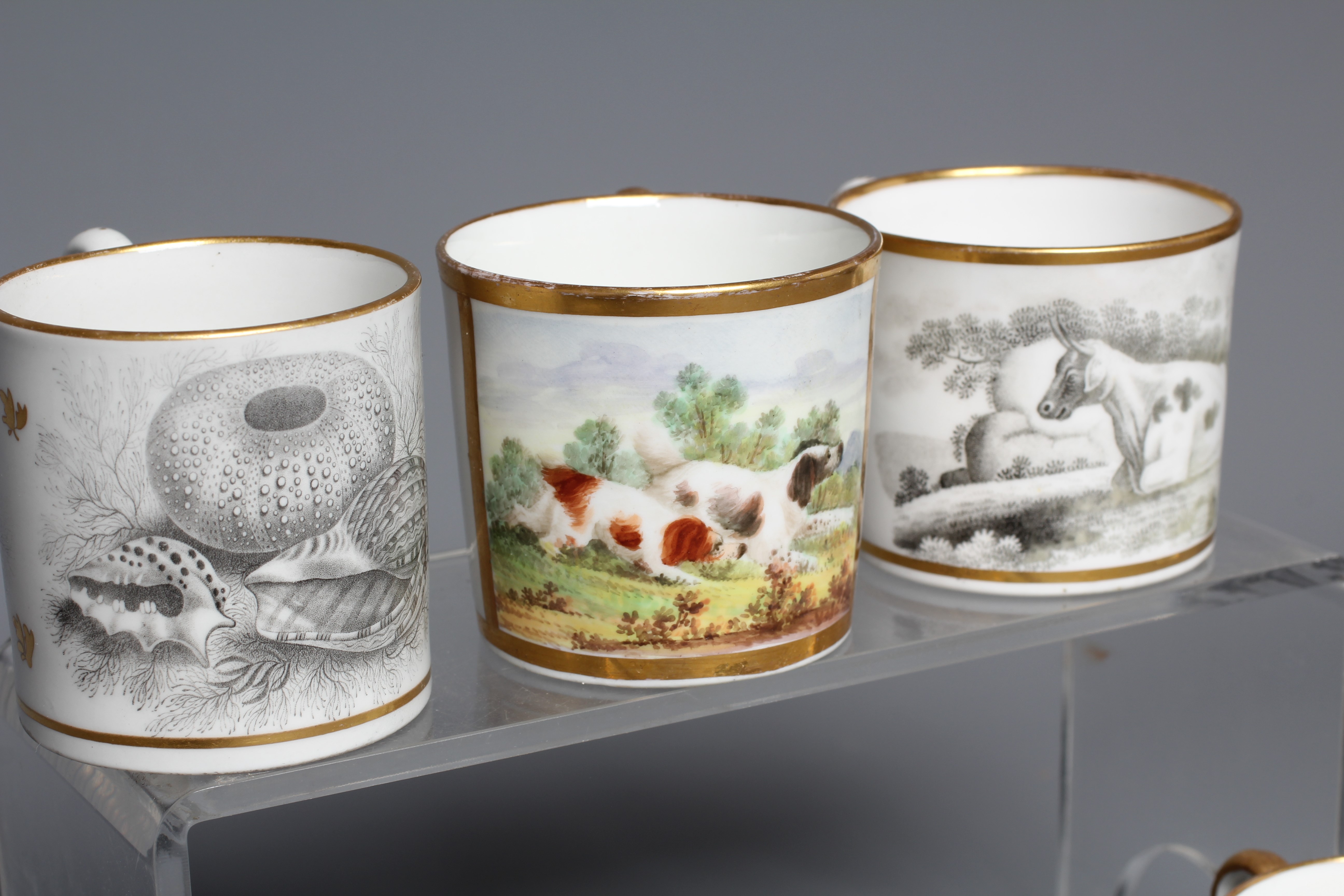 A SET OF THREE ENGLISH PORCELAIN COFFEE CANS painted in polychrome enamels with a gilt square panel Image