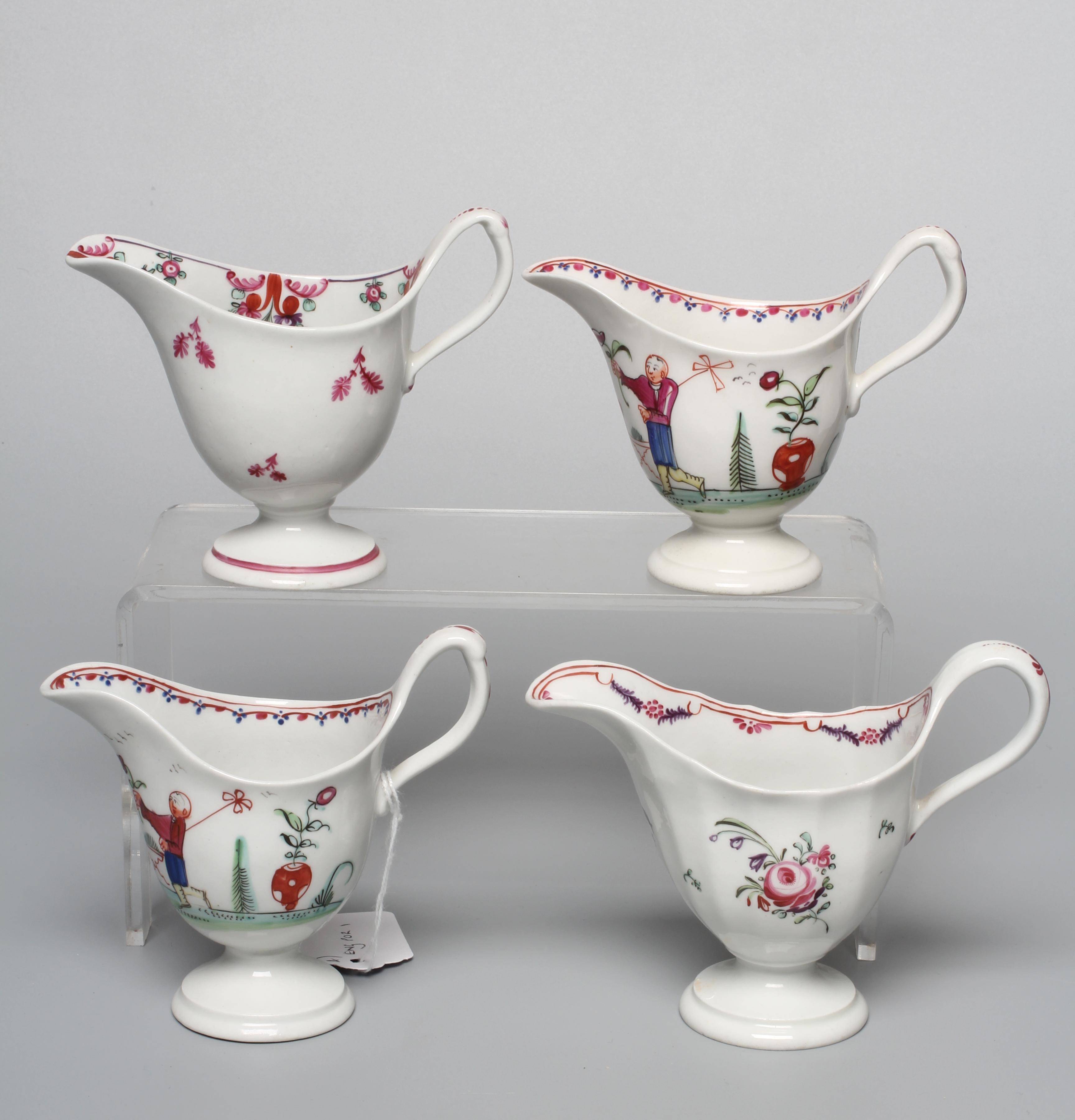 TWO NEWHALL PORCELAIN HELMET CREAM JUGS both with clip handles and painted in polychrome enamels Image
