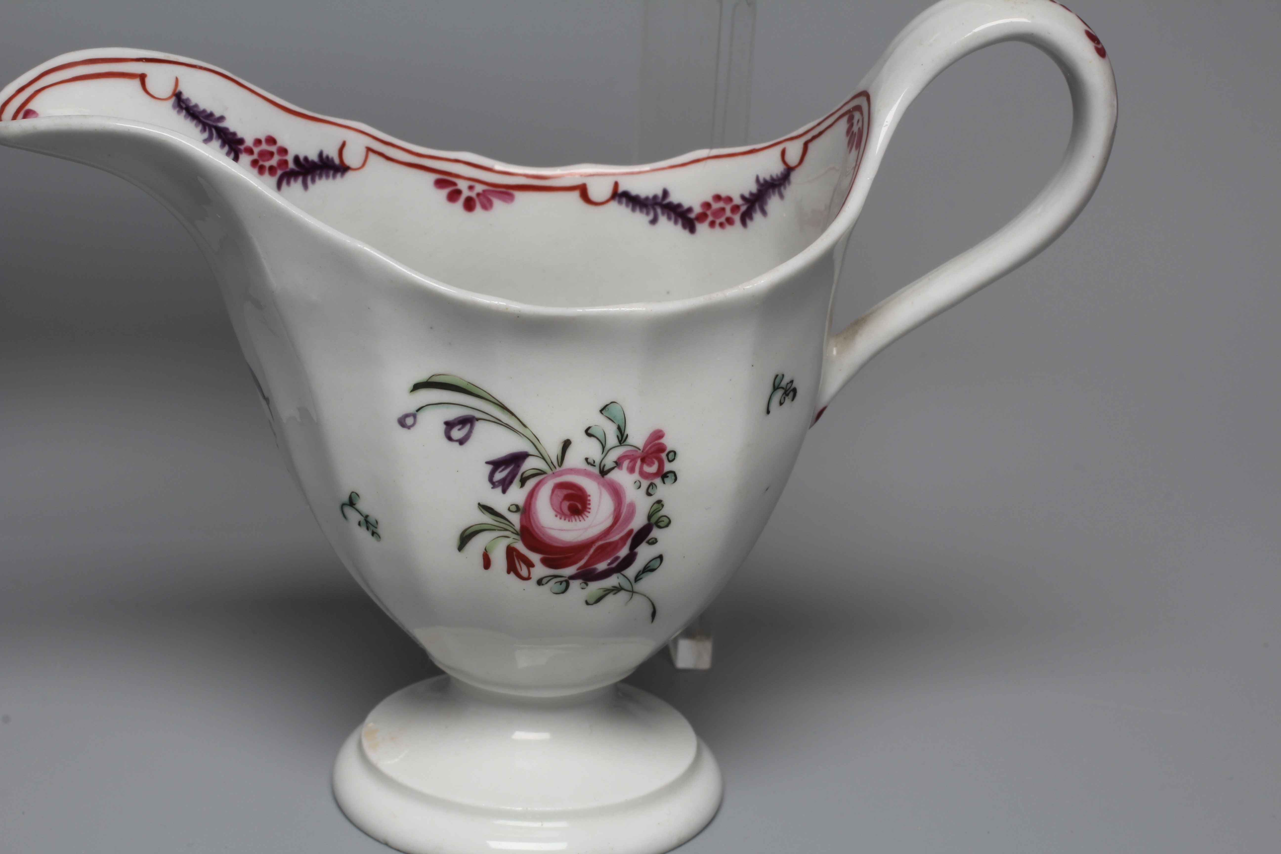TWO NEWHALL PORCELAIN HELMET CREAM JUGS both with clip handles and painted in polychrome enamels Image