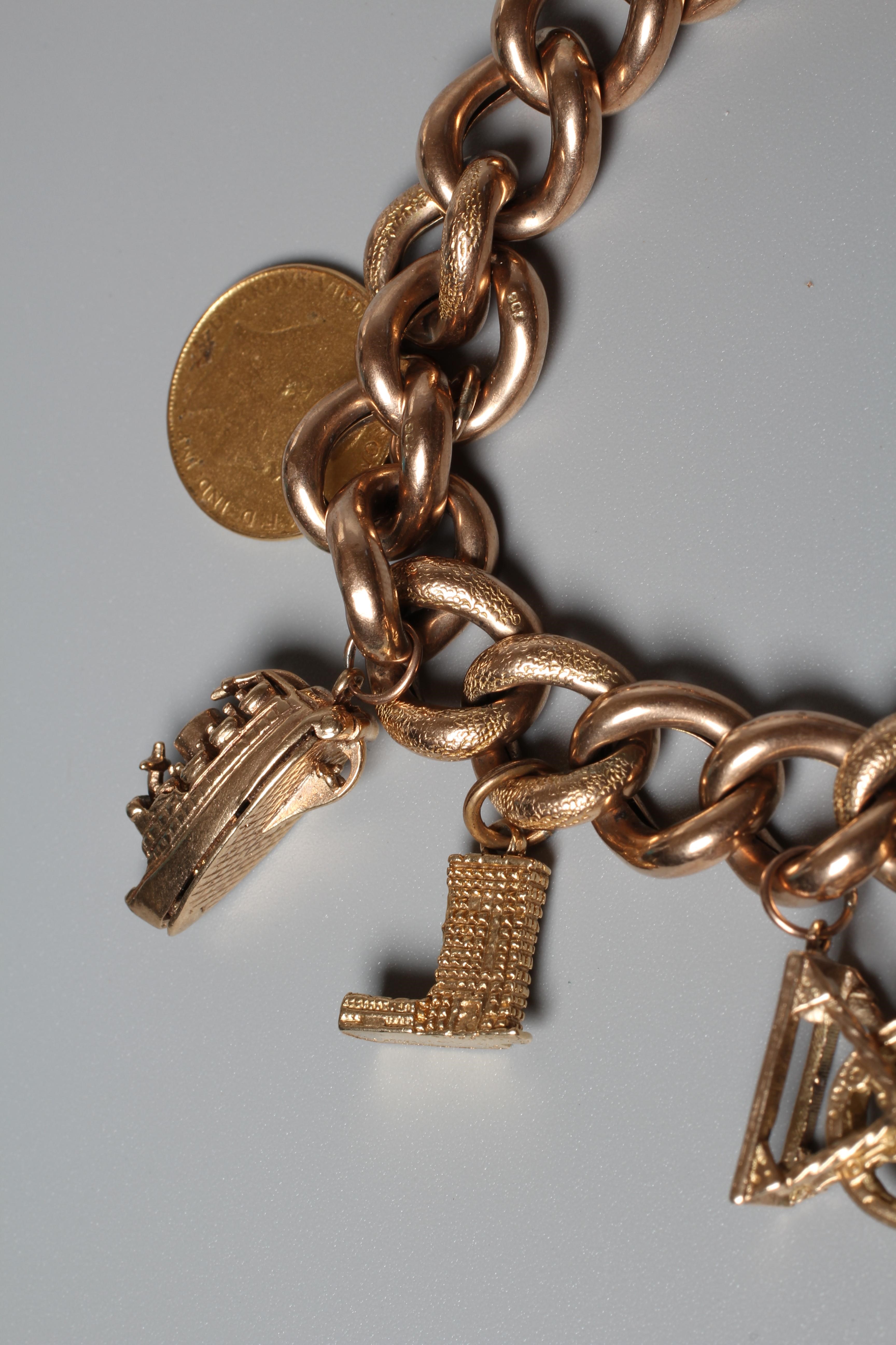 A CURB LINK BRACELET, the foliate engrved links hung with nine charms including a hard mounted 1910 Image