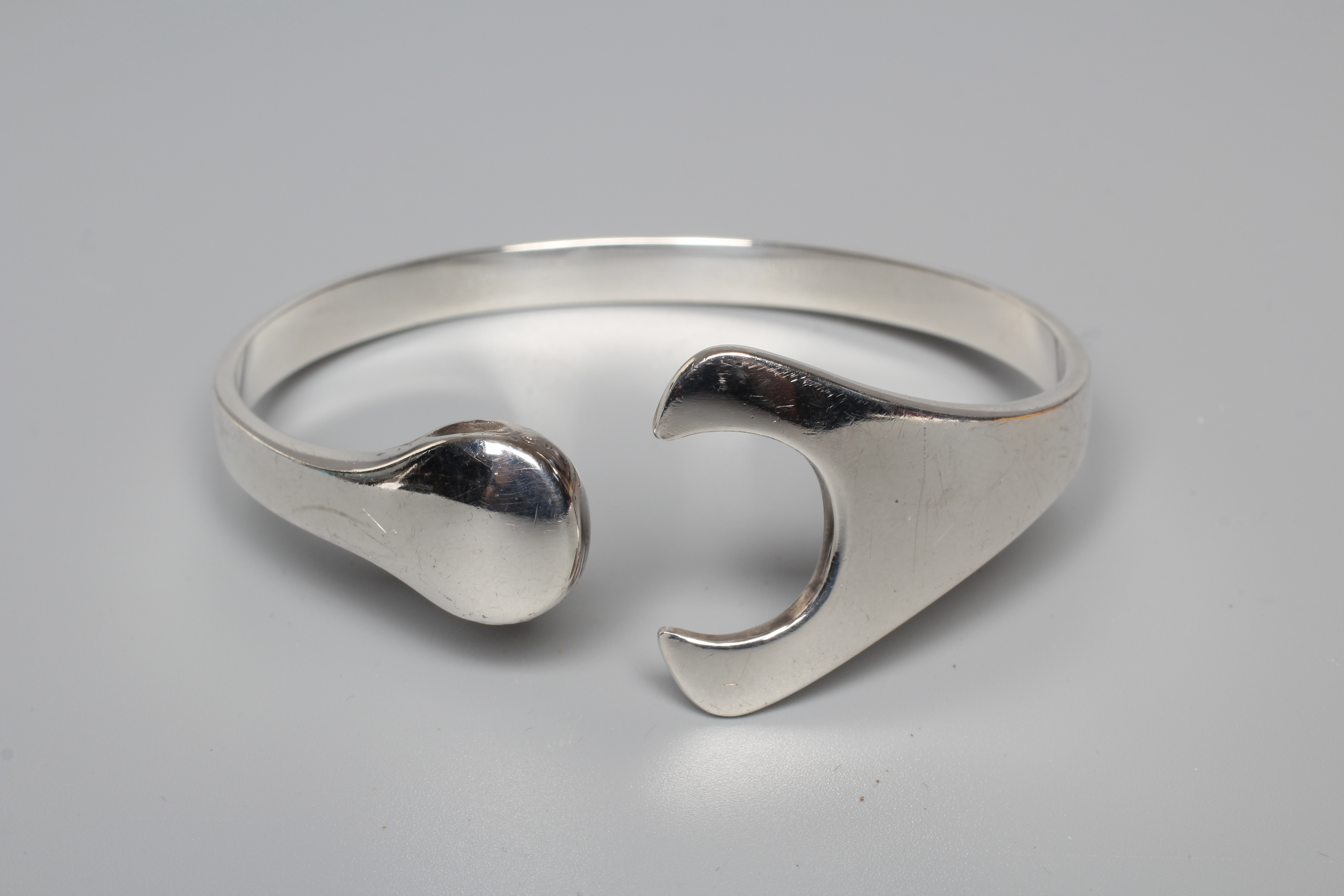 A GEORG JENSEN SILVER PUZZLE BANGLE designed by Hans Hansen, stamped 925, Danmark (Illustrated) Image