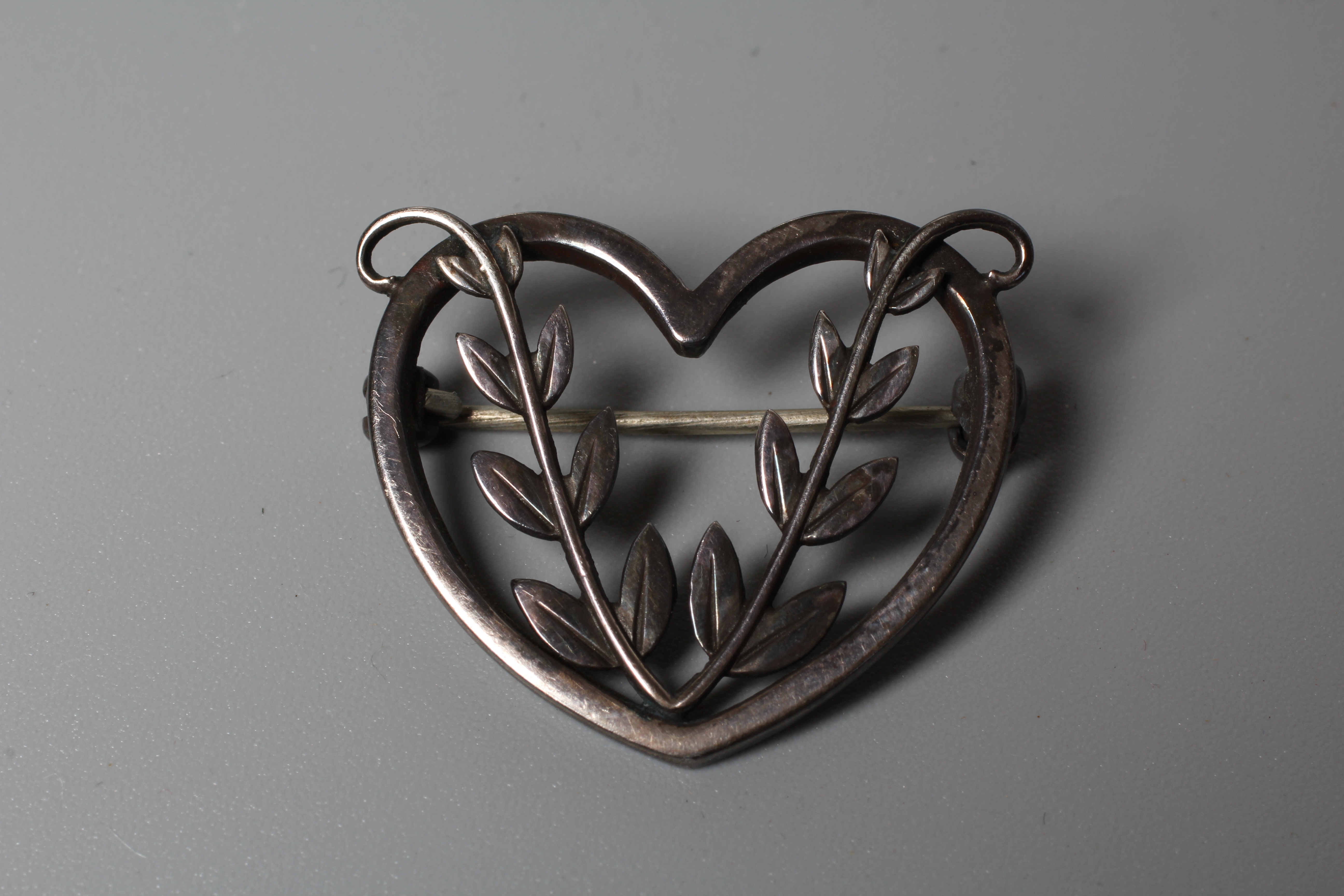 A GEORG JENSEN SILVER HEART BROOCH designed by Arno Malinowski, centred by two leafy fronds, stamped Image