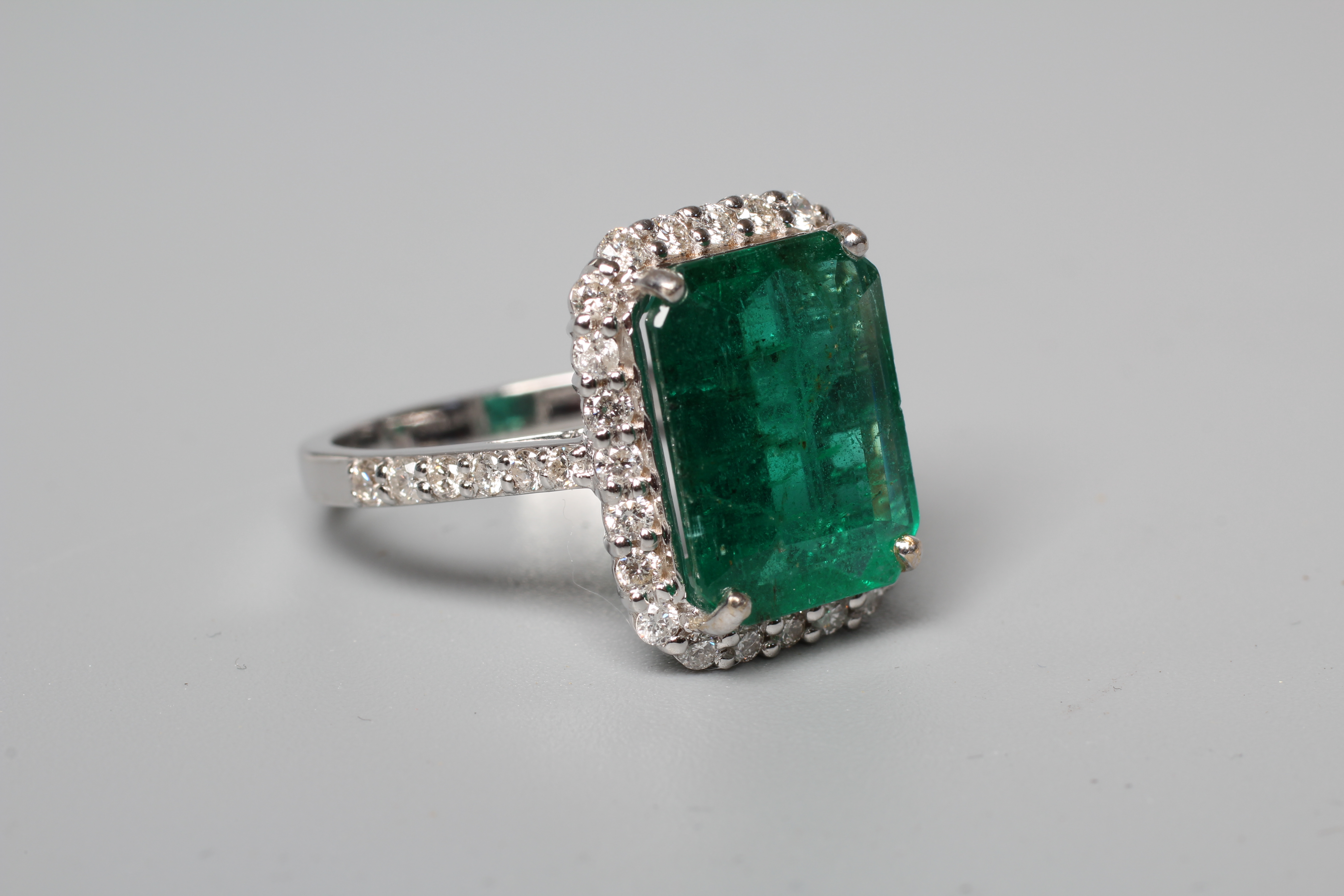 AN EMERALD AND DIAMOND CLUSTER RING Image