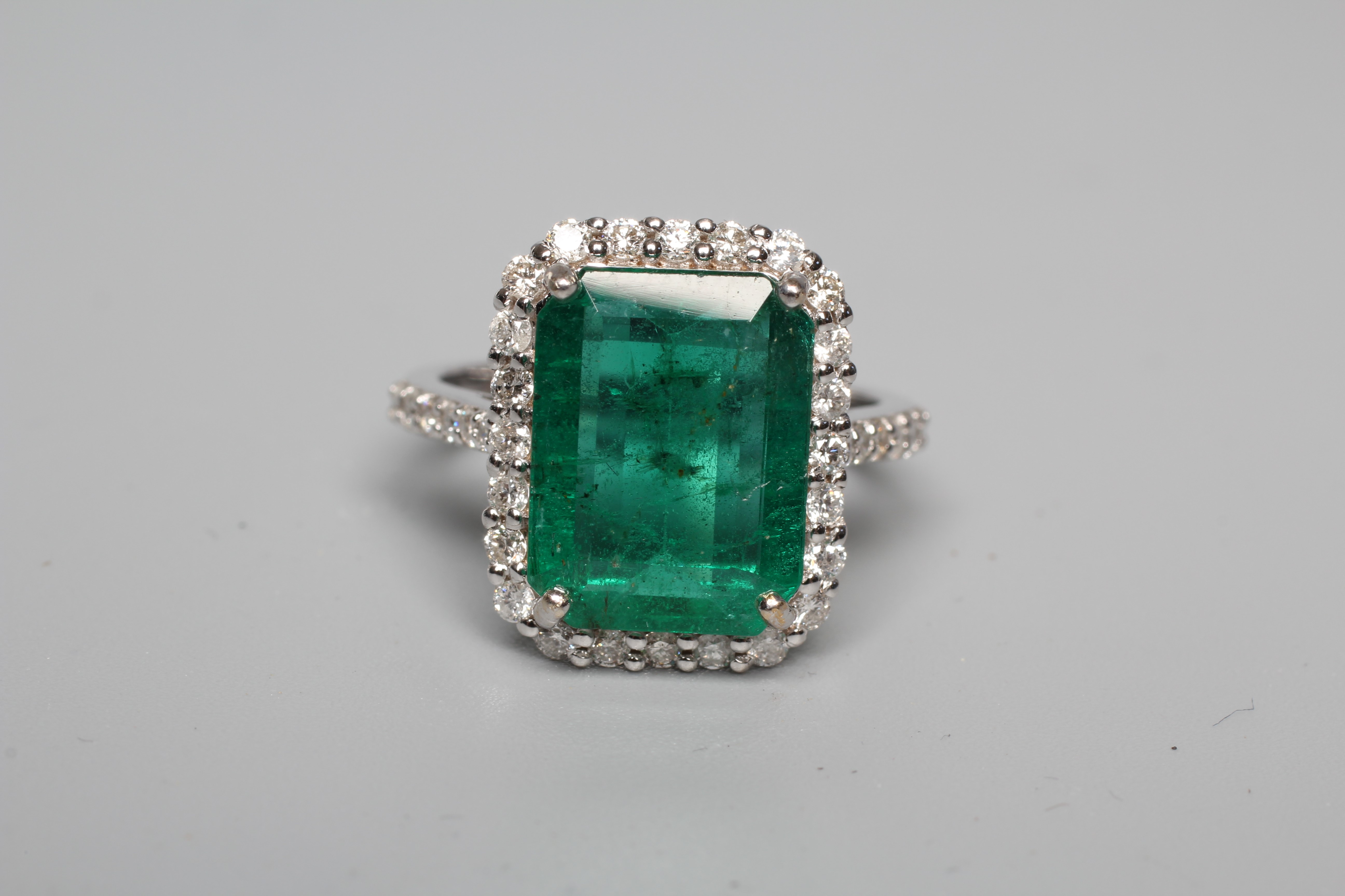 AN EMERALD AND DIAMOND CLUSTER RING Image