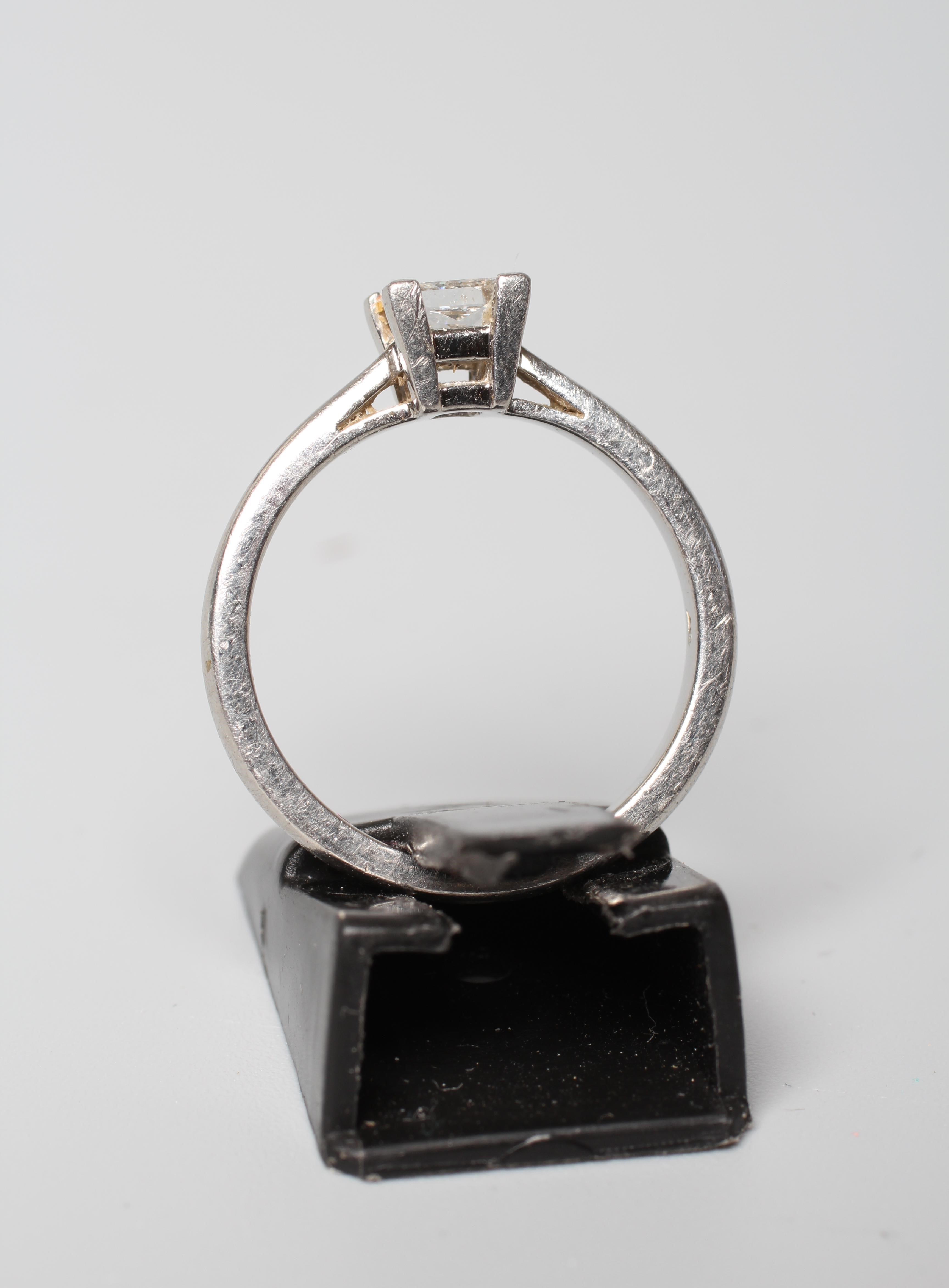 A SOLITAIRE DIAMOND RING, the Princess cut stone of approximately 0.5cts, claw set to a plain Image