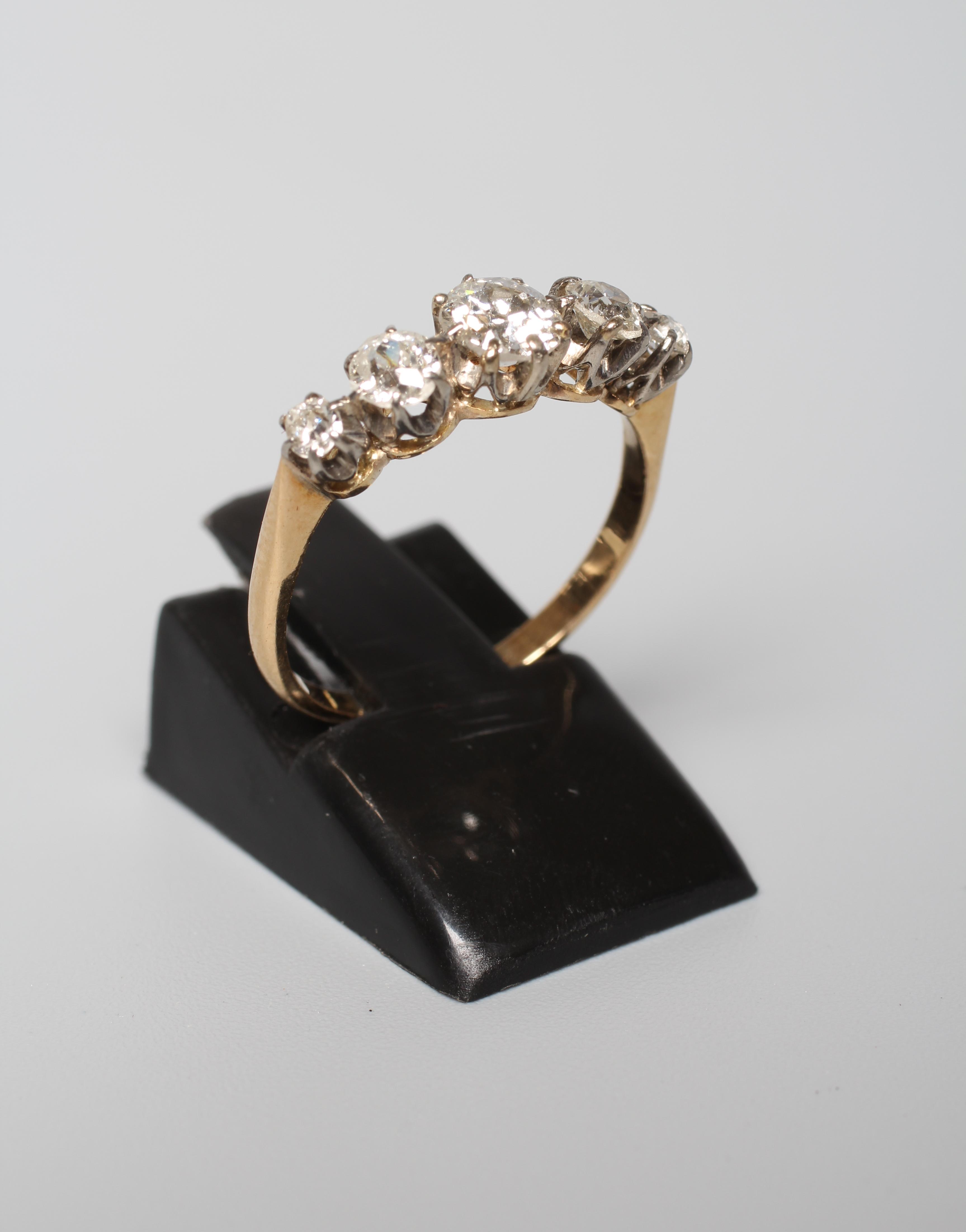 A FIVE STONE DIAMOND RING, the graduating brilliant cut stones claw set to a plain unmarked shank, Image