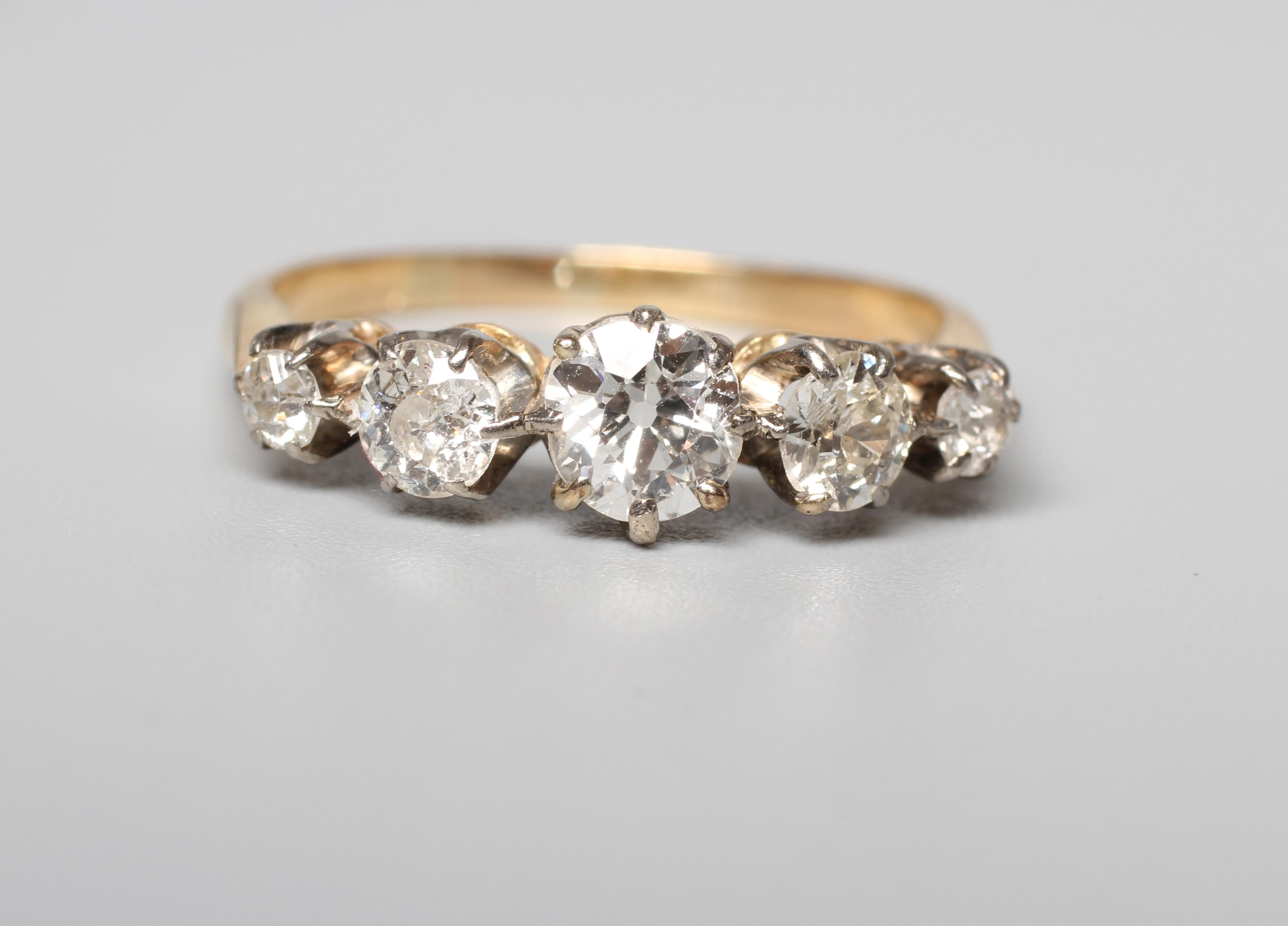A FIVE STONE DIAMOND RING, the graduating brilliant cut stones claw set to a plain unmarked shank, Image