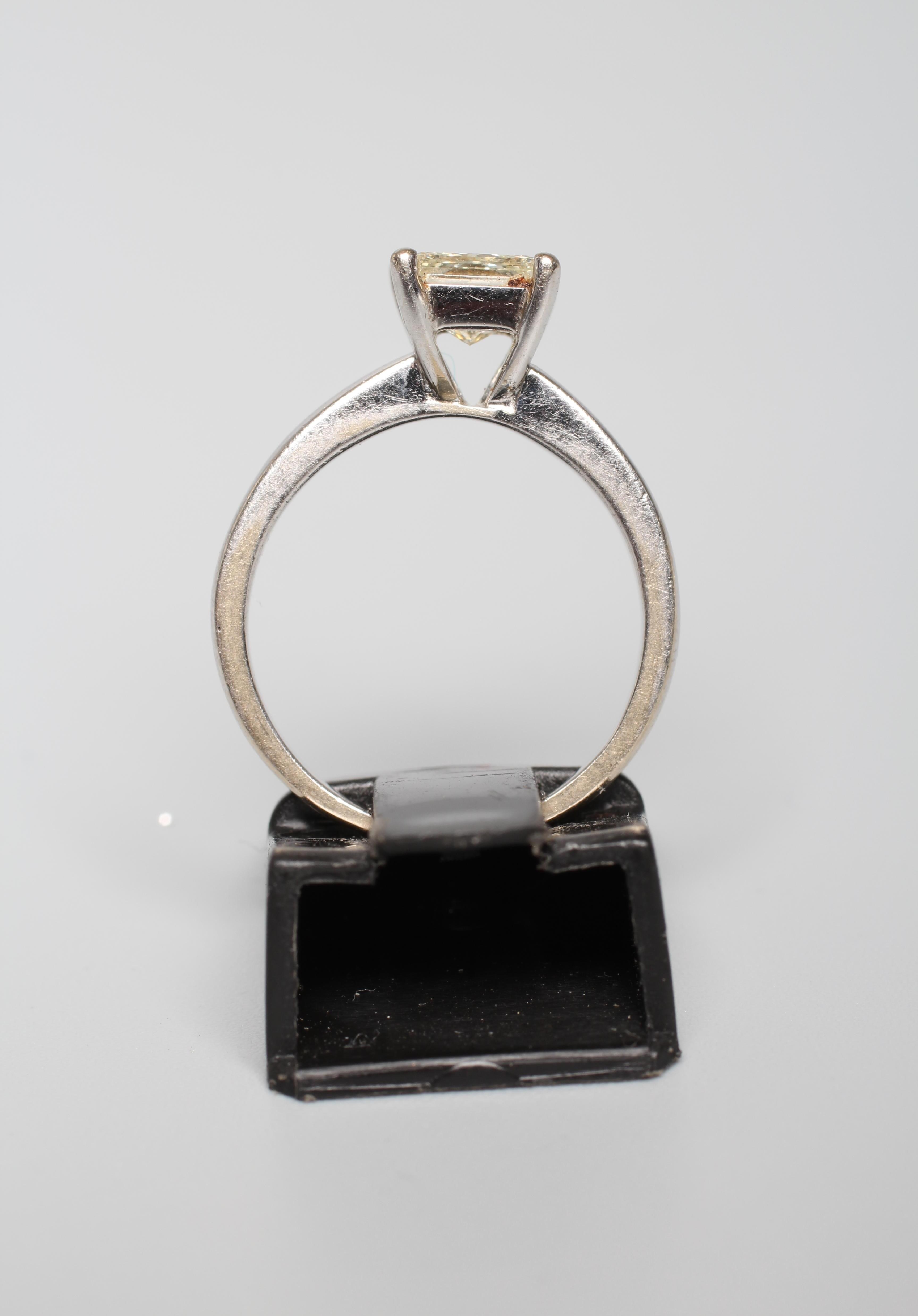 A SOLITAIRE DIAMOND RING, the Princess cut stone of approximately 1ct, claw set to a plain white Image
