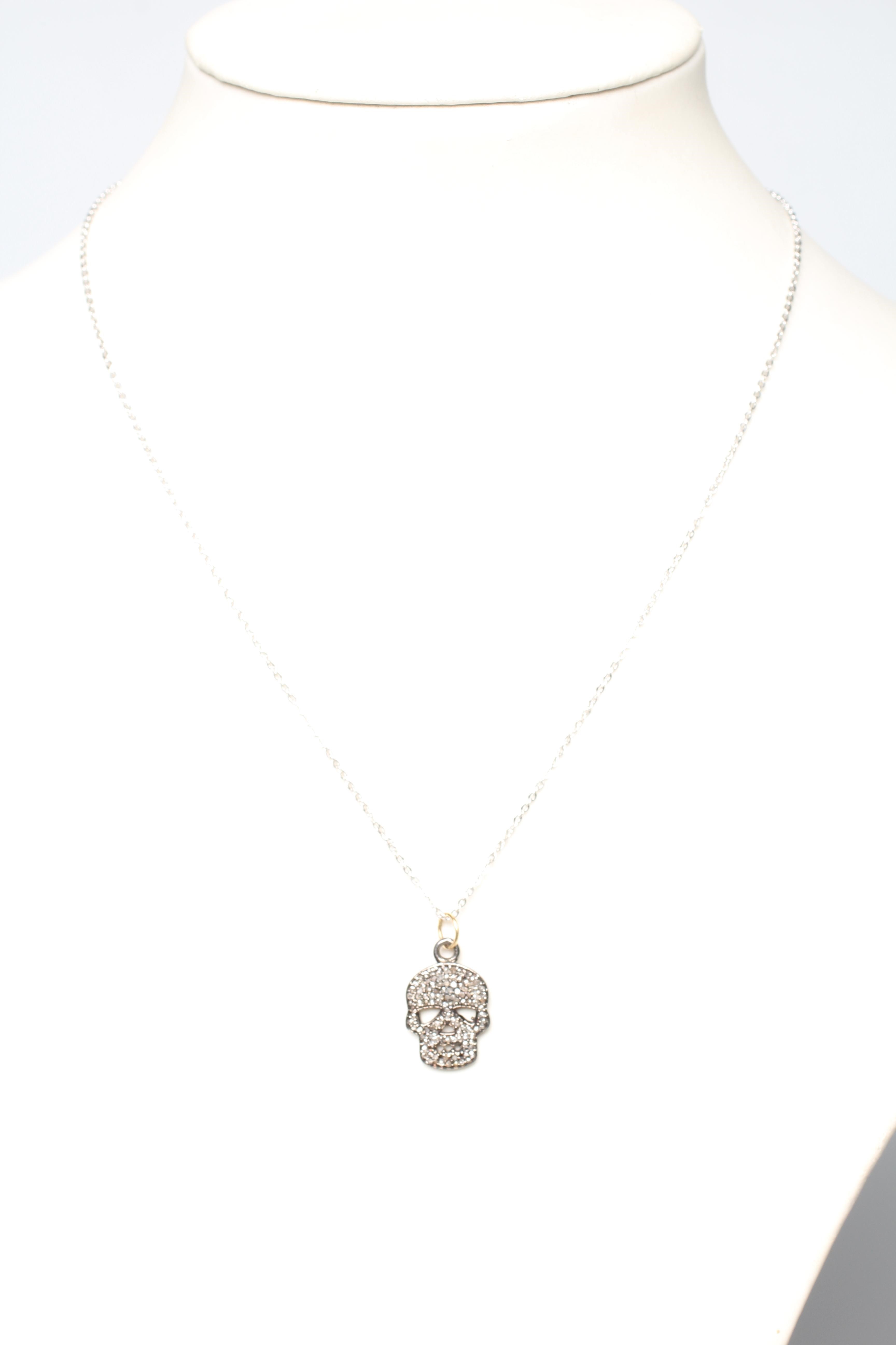A DIAMOND SKULL PENDANT, the numerous rose cut stones pave set to a silver mount, on a silver chain Image