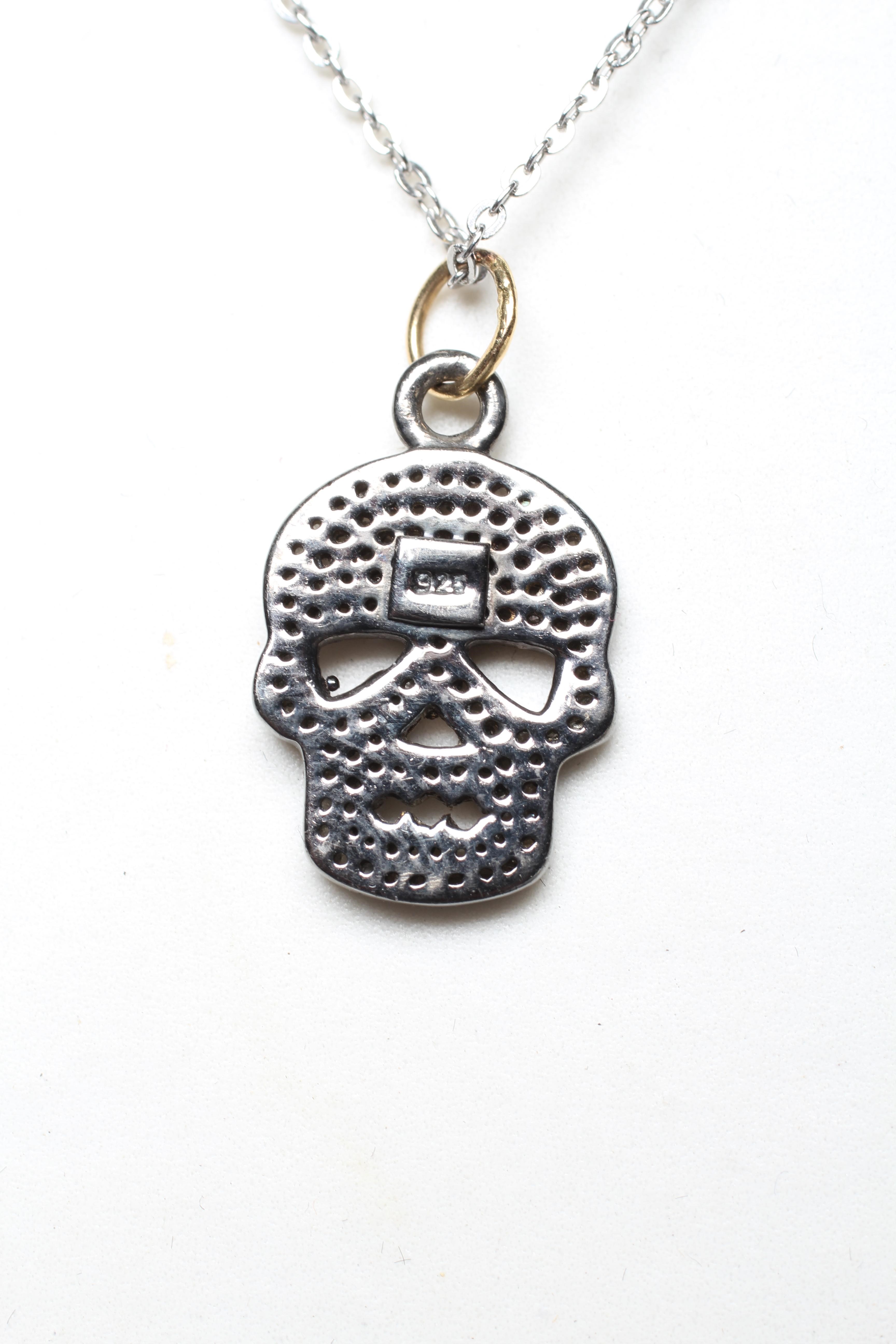 A DIAMOND SKULL PENDANT, the numerous rose cut stones pave set to a silver mount, on a silver chain Image