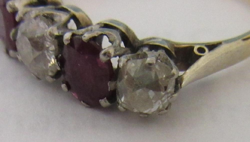 A RUBY AND DIAMOND FIVE STONE RING, the two oval facet cut rubies claw set with three graduating mix Image