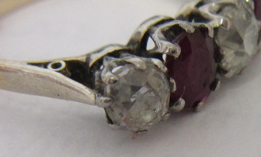 A RUBY AND DIAMOND FIVE STONE RING, the two oval facet cut rubies claw set with three graduating mix Image