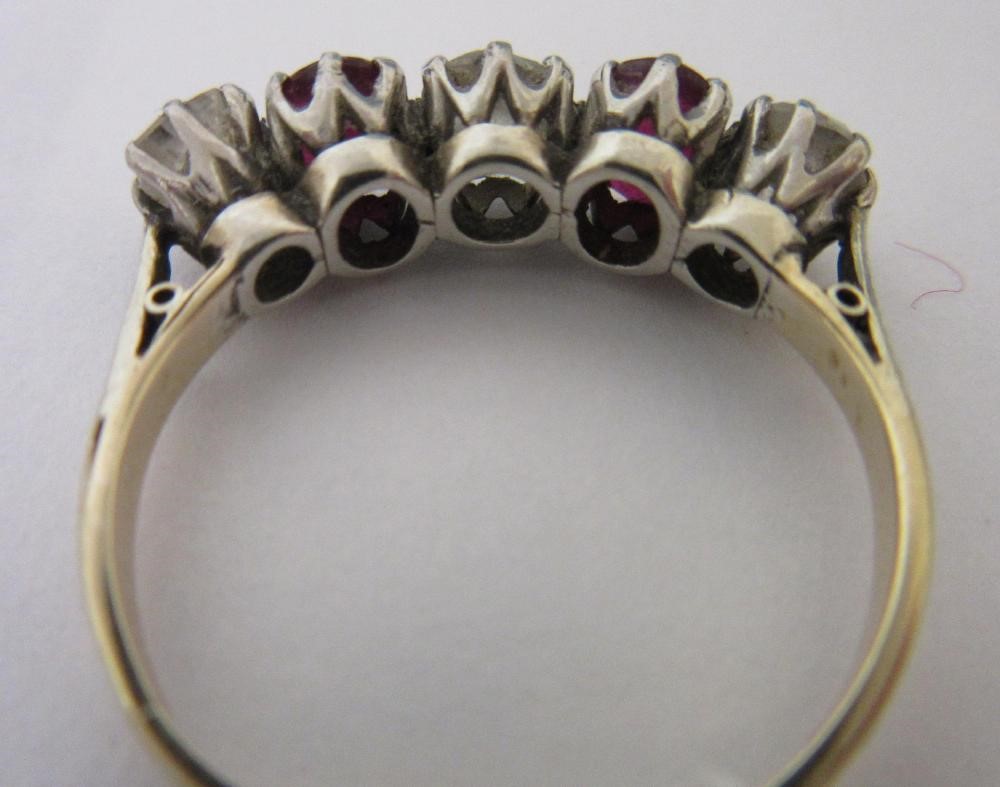 A RUBY AND DIAMOND FIVE STONE RING, the two oval facet cut rubies claw set with three graduating mix Image