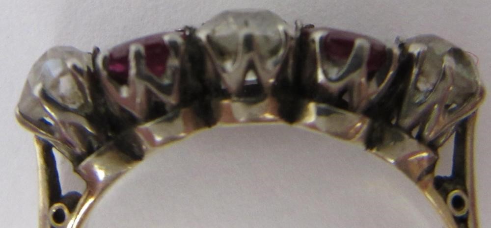 A RUBY AND DIAMOND FIVE STONE RING, the two oval facet cut rubies claw set with three graduating mix Image