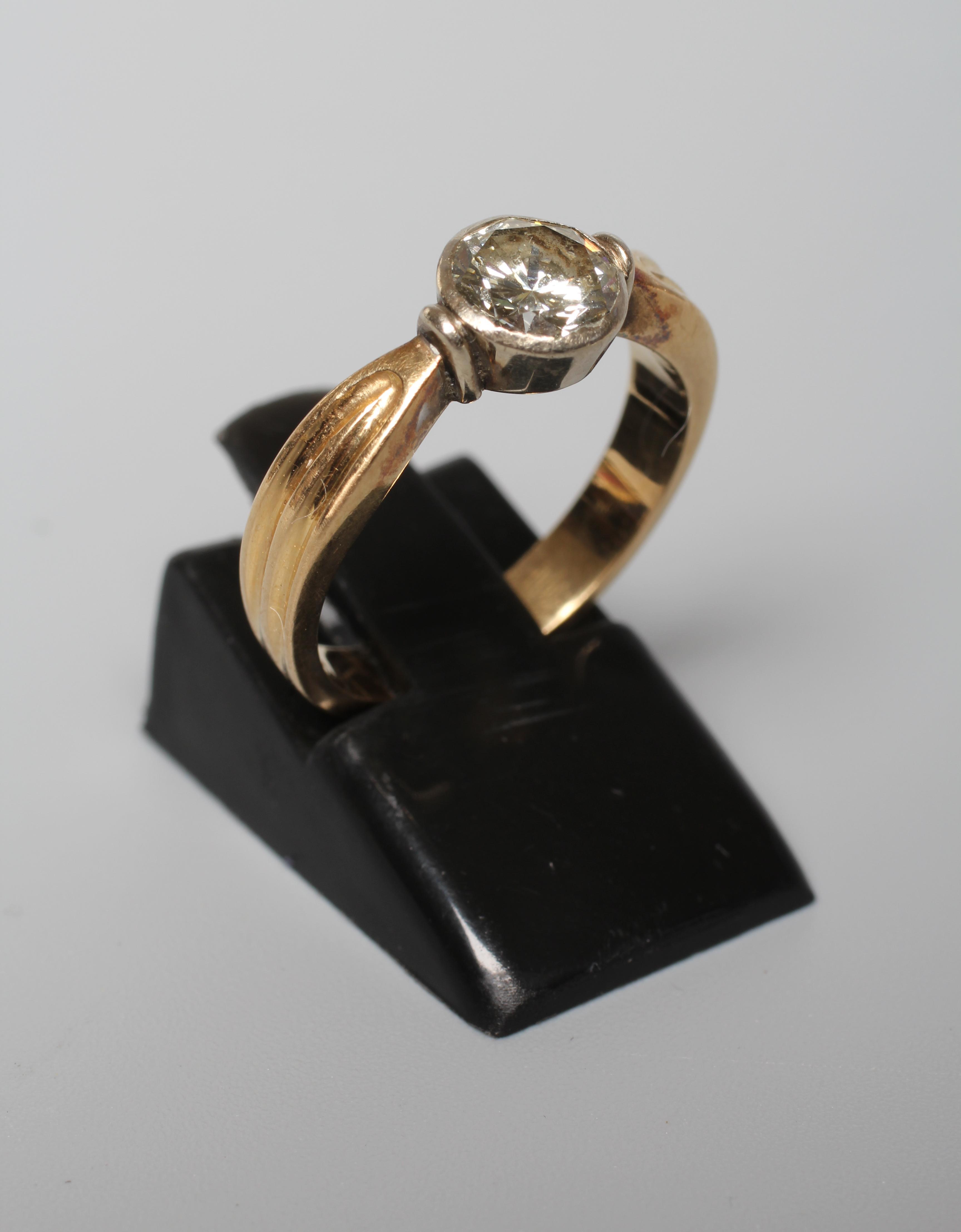A SOLITAIRE DIAMOND RING, the old brilliant cut stone of 1.10cts in a rub-over setting to ribbed Image