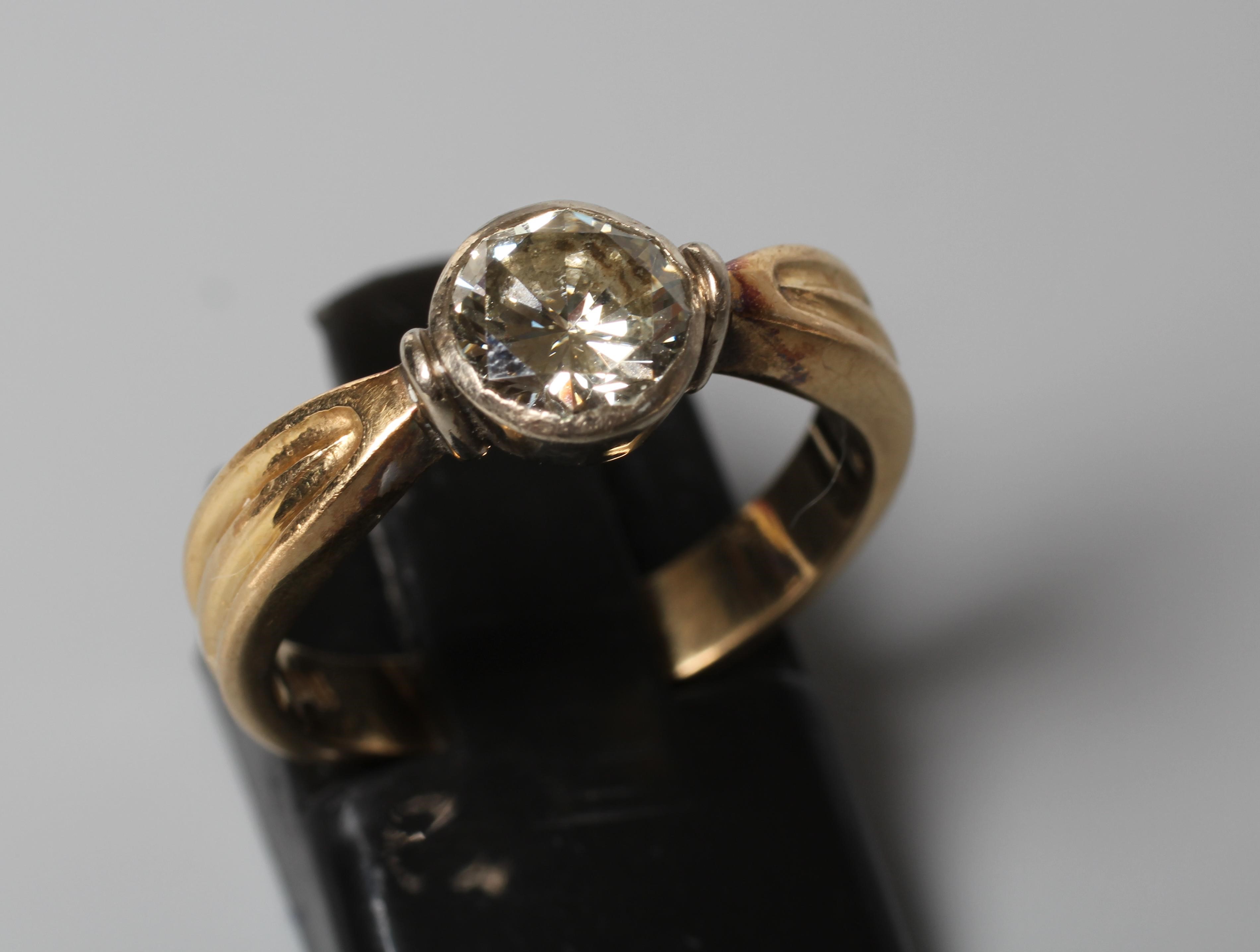 A SOLITAIRE DIAMOND RING, the old brilliant cut stone of 1.10cts in a rub-over setting to ribbed Image