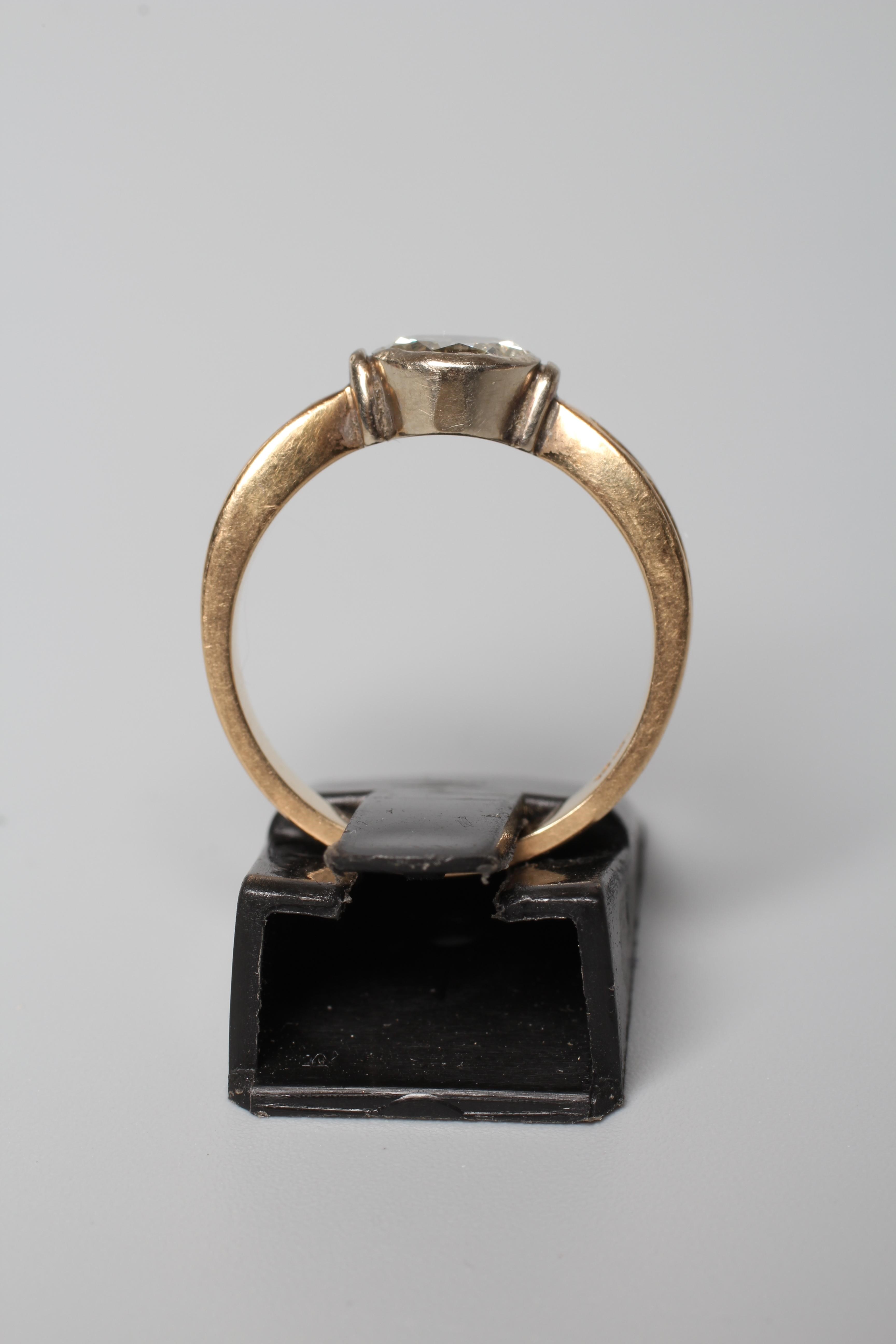 A SOLITAIRE DIAMOND RING, the old brilliant cut stone of 1.10cts in a rub-over setting to ribbed Image
