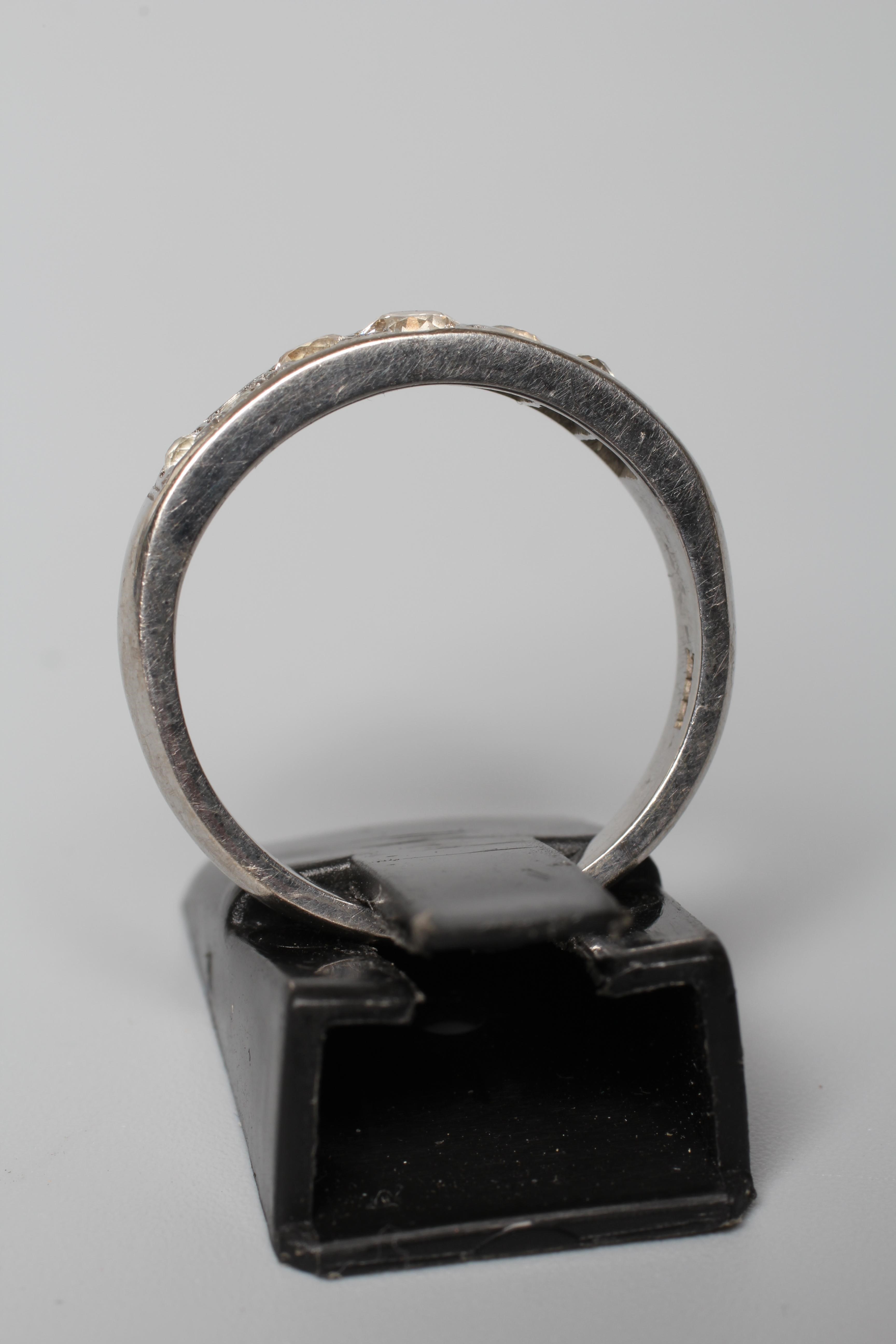 A SEVEN STONE DIAMOND HALF HOOP ETERNITY RING, the graduating stones in rub over setting to a plain Image